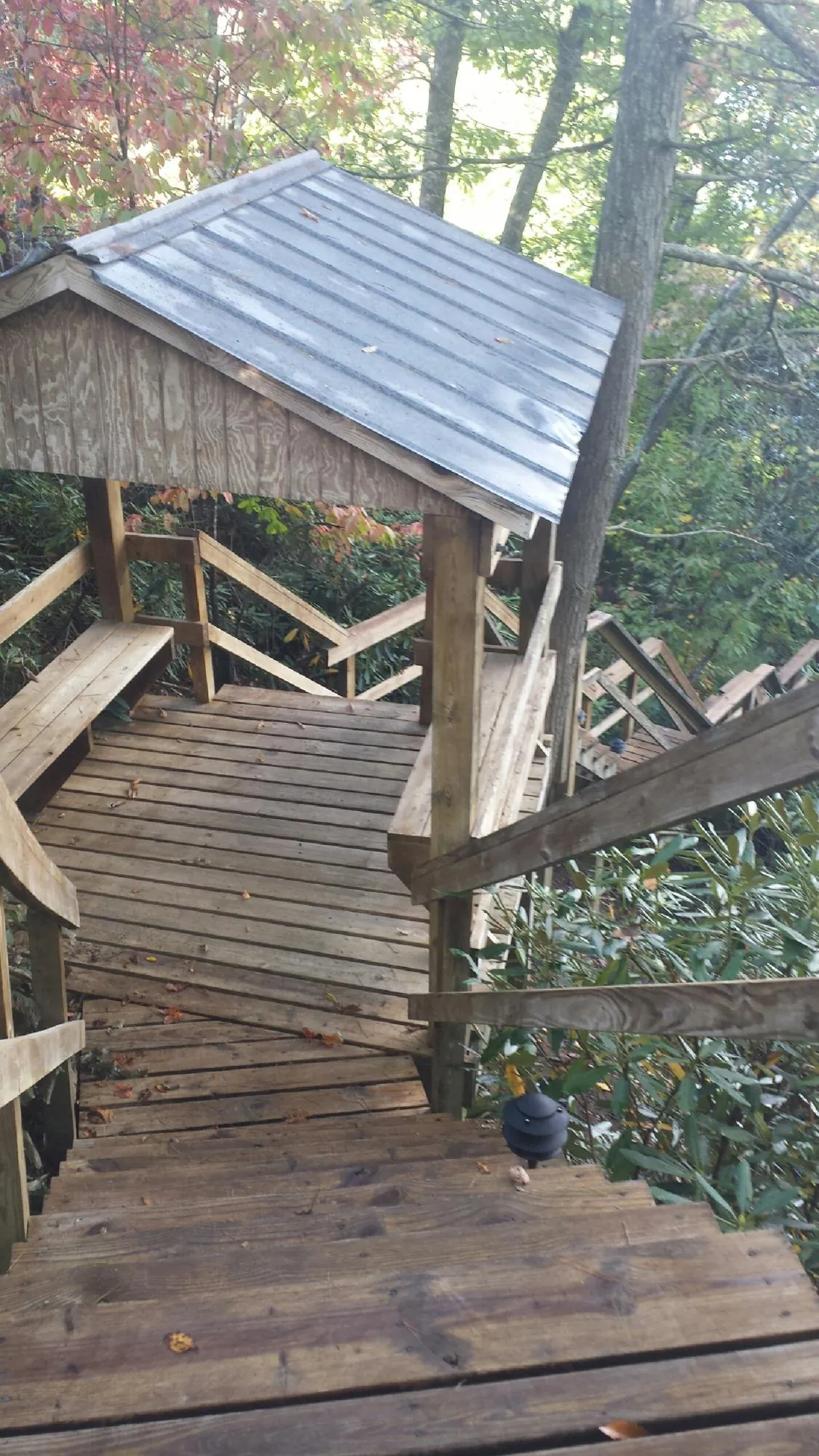 Metal roofed shelter over wooden steps on a wooded walkway — Skylight Repair & Installation work by our crew in Floral Park