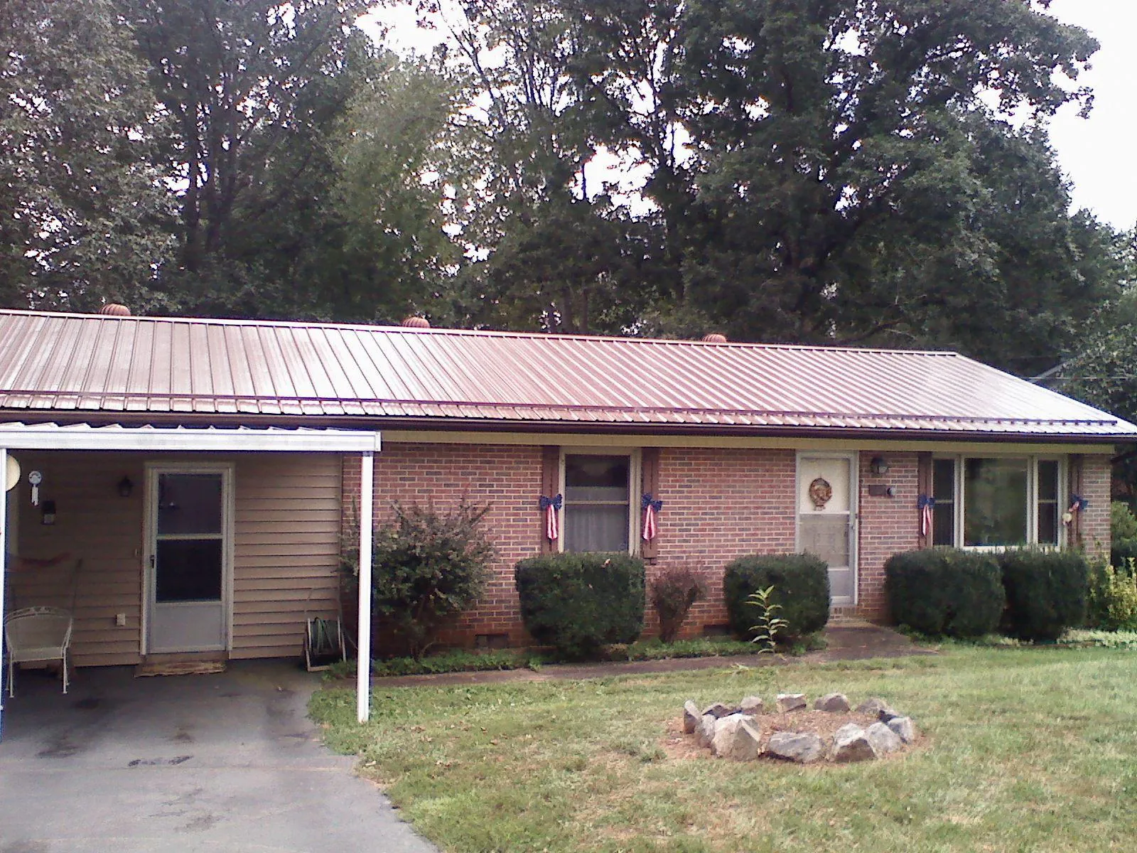 Bronze metal roof and carport on a brick ranch home — Roof Repair work by our crew in Floral Park